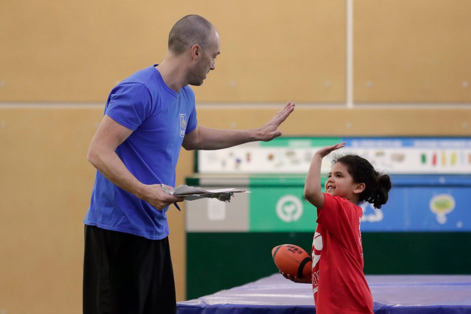 KidSport Volunteer high fives young child
